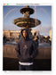 Teo wearing the Liberation Hoodie in india ink, hood up, at a fountain in Paris