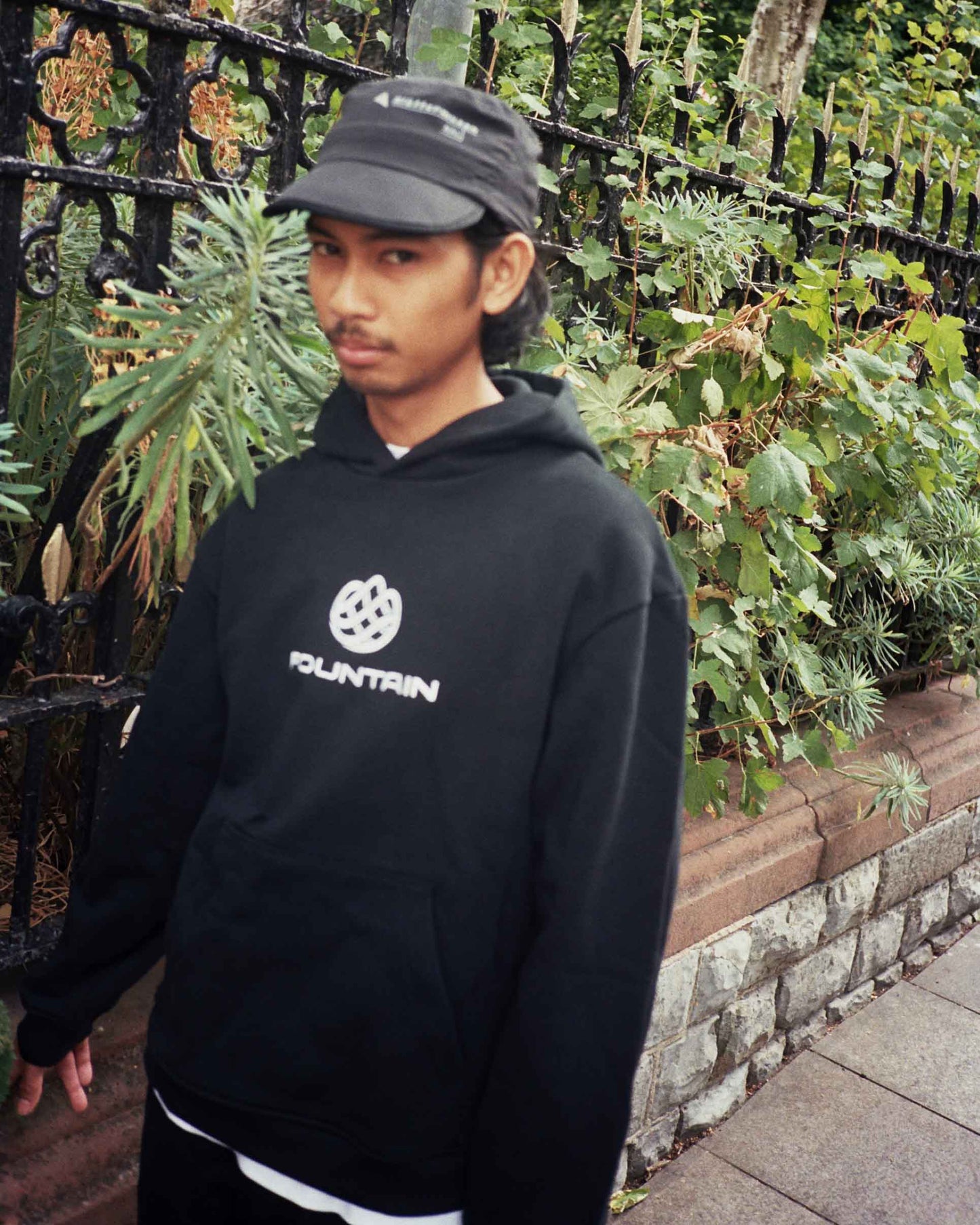 Don wearing the Monogram Hoodie in black with a cap