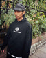 Don wearing the Monogram Hoodie in black with a cap