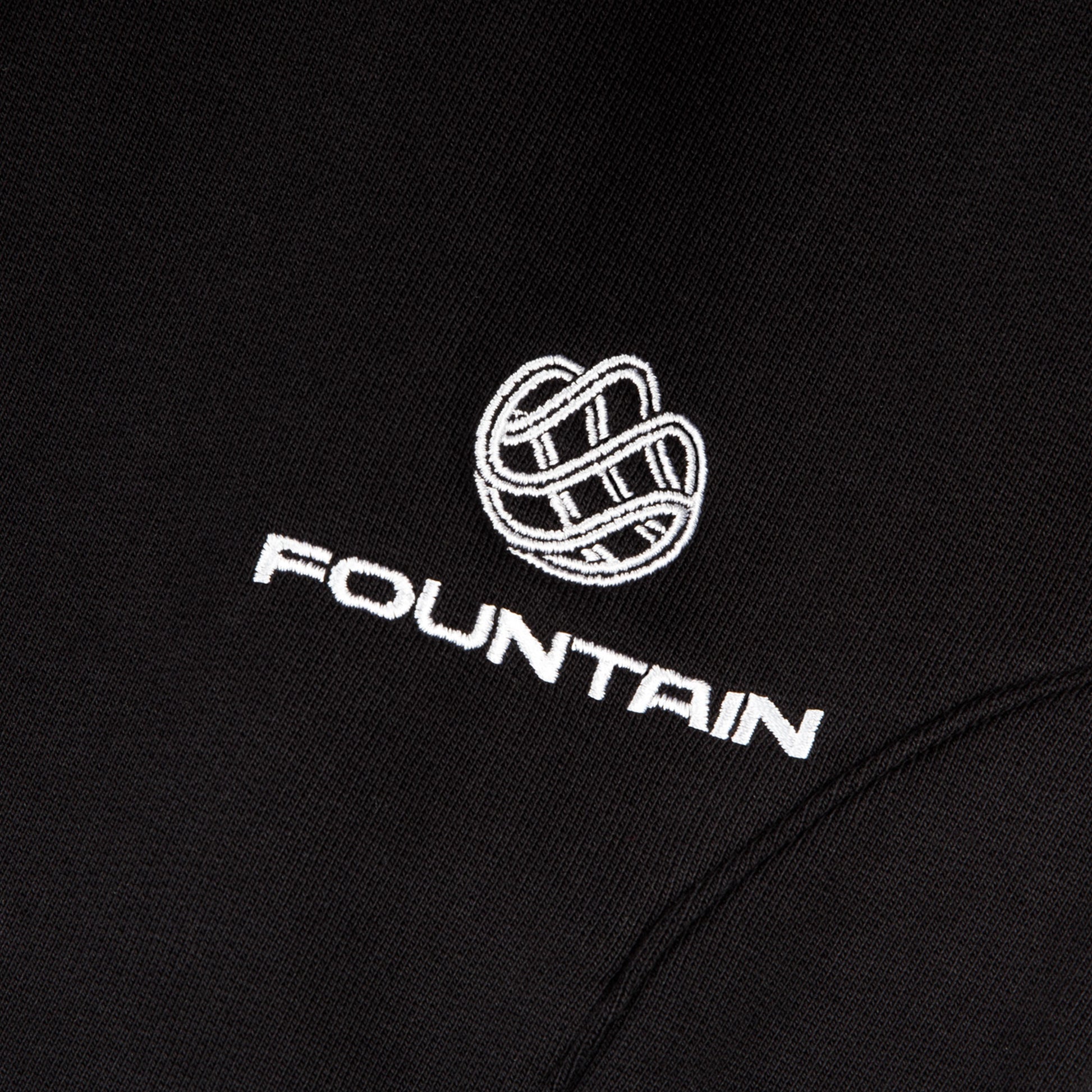 Close detail of the embroidered Fountain monogram at the left pocket